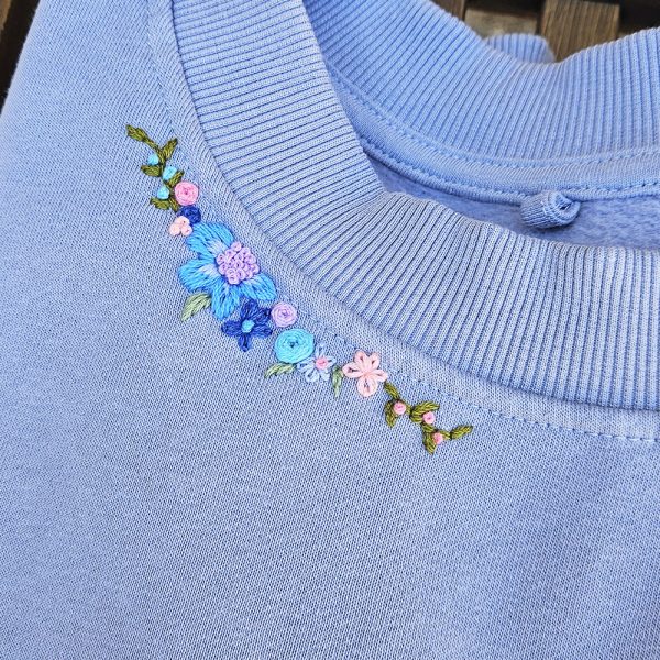 Sudadera bordada a mano con mensaje original, estilo artesanal.