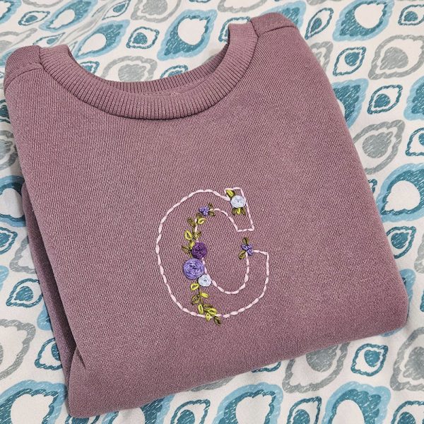 Sudadera personalizada con iniciales bordadas a mano sobre tela de algodón.